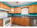 Kitchen with teal walls, wood cabinets, and stainless steel appliances at 315 Watts Rd, Hiram, GA 30141