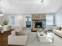 Virtually staged living room features a stone fireplace and hardwood floors at 4762 Huntsman Bnd, Decatur, GA 30034