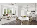 Open concept living room and kitchen with L-shaped sofa and dining area at 201 Devore Rd, Alpharetta, GA 30009