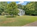 Side view of a gray house with a large yard and lush landscaping at 4050 Harvest Ridge Dr, Douglasville, GA 30135