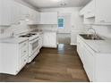 Bright kitchen with white cabinets and flooring at 145 Dunwick Ln, Mcdonough, GA 30253