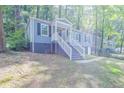 Inviting blue house nestled amongst lush green trees, a walkway leads to the entrance at 2836 Harlan Dr, Atlanta, GA 30344