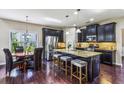 Modern kitchen with dark cabinetry, granite island, and stainless steel appliances at 2617 Jupiter Sw Dr, Powder Springs, GA 30127