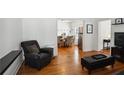 Living room with hardwood floors, black leather sofa, and view of kitchen at 618 Daniel Se Ave, Decatur, GA 30032