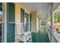 Inviting front porch with rocking chair and green floor at 1486 Willow Bnd, Woodstock, GA 30188