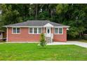 Brick Ranch home with a large front yard, driveway, and landscaping at 690 Green Acres Se Rd, Smyrna, GA 30080