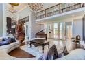 Elegant living room with double-height ceilings, spiral staircase, and grand piano at 9620 Cedar Grove Rd, Chattahoochee Hills, GA 30213