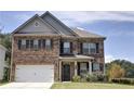 Brick two-story house with a large white garage door and landscaped lawn at 222 Gallant Fox Way, Acworth, GA 30102
