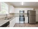 Kitchen with white shaker cabinets, granite countertops, and stainless steel appliances at 280 Green Commons Dr, Covington, GA 30016