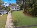 Attractive house with a large front yard and driveway, surrounded by trees at 1630 Ezra Church Nw Dr, Atlanta, GA 30314
