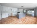 Modern kitchen with white cabinets, gray island, and hardwood floors at 1630 Ezra Church Nw Dr, Atlanta, GA 30314