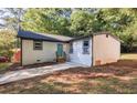 Updated home with white siding, teal door, and a long driveway at 4131 Tara Dr, Forest Park, GA 30297