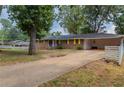Brick ranch house with yellow shutters, driveway and carport at 3689 Laurie Woods Ln, Decatur, GA 30034