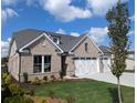 Brick home with three car garage and landscaping at 2135 Windsor Bluffs Dr, Cumming, GA 30041