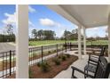 Covered front porch with rocking chairs, offering a view of the landscaped yard and neighborhood at 1988 Amaryllis Dr, Grayson, GA 30017