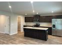 Modern kitchen with dark cabinets, granite countertops, and island at 3290 Forest Green Dr, Douglasville, GA 30135
