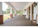 Spacious front porch with wooden flooring and brick columns at 234 E Main St, Rutledge, GA 30663