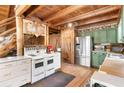 Rustic kitchen with exposed beams, stainless steel appliances, and farmhouse charm at 7790 Atlanta Newnan Rd, Chattahoochee Hills, GA 30268