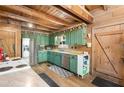 Rustic kitchen with exposed beams, stainless steel appliances, and farmhouse charm at 7790 Atlanta Newnan Rd, Chattahoochee Hills, GA 30268