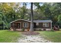 Single-story home with dark brown siding, stone accents, and a covered porch at 116 Southside Dr, Villa Rica, GA 30180