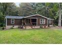 Single-story home with dark brown siding, stone accents, and a covered porch at 116 Southside Dr, Villa Rica, GA 30180