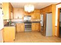 Kitchen with light wood cabinets, stainless steel appliances, and laminate flooring at 3219 Boulder Brook Dr, Lithonia, GA 30038
