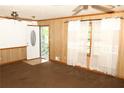 Living room features wood paneling, carpet, and a large window with curtains at 3219 Boulder Brook Dr, Lithonia, GA 30038