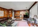 Living room with wood walls, brown leather couch, and a view of the kitchen at 2293 Ewing Sw St, Atlanta, GA 30331