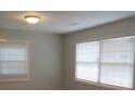 Simple bedroom with neutral walls, vinyl flooring and two windows at 973 Neal Nw St, Atlanta, GA 30314