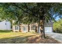 Two-story house with a large tree in front and a two car garage at 6696 Pine Valley Trce, Stone Mountain, GA 30087