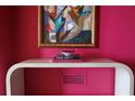 Modern console table with artwork and books in a pink room at 88 W Paces Ferry Nw Rd # 1130, Atlanta, GA 30305