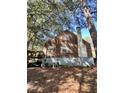 Rear view of a wood-sided home showcasing a deck and surrounding landscape at 1876 Madrona Nw St, Atlanta, GA 30318