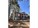 Side view of a charming ranch home with wood siding and a tree-lined setting at 1876 Madrona Nw St, Atlanta, GA 30318