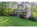 Ranch style home with a red door and large green lawn at 4323 Autumn Hill Dr, Stone Mountain, GA 30083