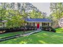 Ranch home features a red front door and nicely landscaped yard at 4323 Autumn Hill Dr, Stone Mountain, GA 30083