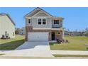 Two-story home with gray siding, brick accents, and a two-car garage at 247 Tulip Dr, Covington, GA 30016