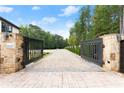 Private gated entrance with brick pavers and lush landscaping at 2635 Camp Branch Rd, Buford, GA 30519