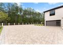 Expansive brick paver driveway leading to a modern garage at 2635 Camp Branch Rd, Buford, GA 30519