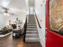 Entryway with red door, staircase, and view into living room at 180 Maddox Rd, Buford, GA 30518