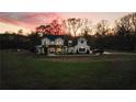 Farmhouse with large yard and driveway, beautiful sunset in the background at 4165 Milford Trl, Cumming, GA 30028