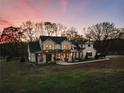 Two-story farmhouse with a metal roof, large yard, and beautiful sunset at 4165 Milford Trl, Cumming, GA 30028