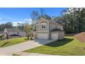 Two-story house with gray siding, a three-car garage, and a well-manicured lawn at 2798 Cromwell Ln, Snellville, GA 30039