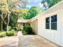 Home's side with mature trees and shrubs at 246 Plantation Sw Rd, Smyrna, GA 30082