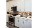 Modern kitchen with white shaker cabinets, herringbone backsplash, and stainless steel appliances at 392 Pratt Se Dr # 2012, Atlanta, GA 30315