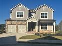 Two-story house with gray siding, stone accents, and a three-car garage at 328 Willow Cv, Canton, GA 30114