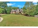 Brick home on a grassy hill with lush landscaping at 1175 Bowerie Chase, Powder Springs, GA 30127