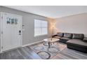 Living room with L-shaped sofa, glass coffee table, and wood-look floors at 2225 Pleasant Hill Rd, Atlanta, GA 30349