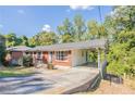 Brick ranch house with a carport and a view of the wooded backyard at 182 Arcadia Nw Cir, Atlanta, GA 30314