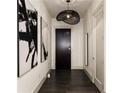 Modern entryway with dark hardwood floors, sleek dark door, and large-scale black and white art at 3107 Peachtree Road Ne Unit #1803, Atlanta, GA 30305