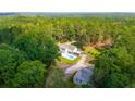 Aerial view of house, pool, and detached garage nestled in a wooded area at 2298 Cole Lake Rd, Dallas, GA 30157